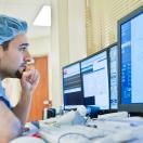 Healthcare worker in scrubs looking at medical image on screen