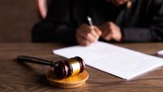 Gavel lies on a table in front of a legal pad