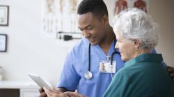 Doctor showing tablet to patient