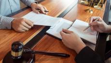 Two people reviewing documents with a gavel nearby