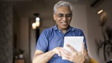 Person smiles as they use an app on a tablet.