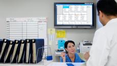 Staff conversing in the nurses' station with the Ascom Digistat Smart Central on the background