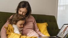 Parent and child attending telehealth appointment on laptop