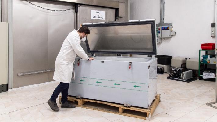 A person looks into a vaccine refrigerator