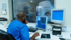 Healthcare worker using computer in MRI control room