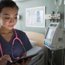 A nurse looking at a digital tablet